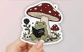 Frog Reading Dark Romance Under Mushroom • Sticker